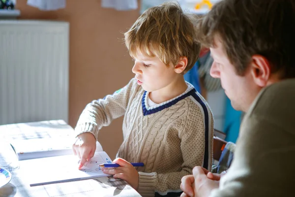 Niño de la escuela feliz y padre en casa haciendo tarea — Foto de Stock