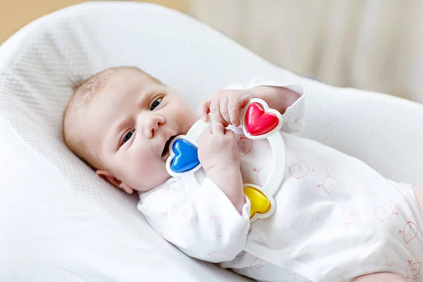 Schattig baby meisje spelen met kleurrijke rammelaar speelgoed — Stockfoto