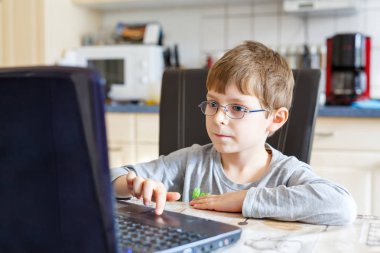 internet'te sörf ve bilgisayarda oynamak gözlüklü çocuk çocuk