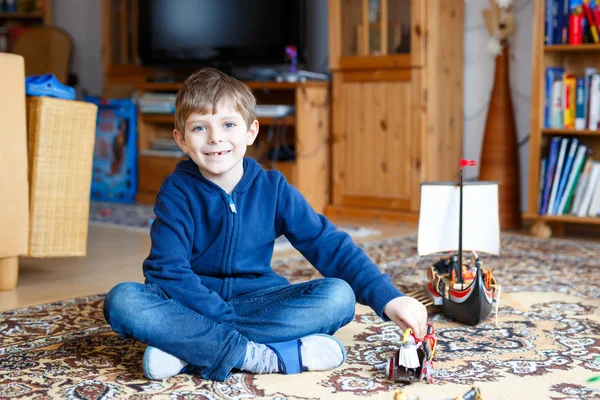 Liten blond förskola kid pojke leker med leksak fartyget inomhus — Stockfoto
