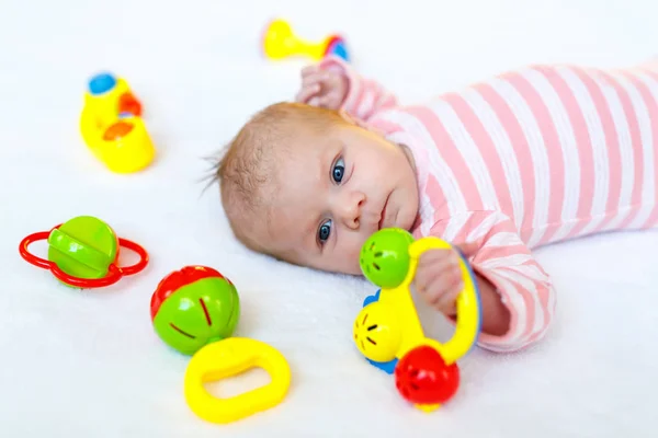 Linda niña jugando con juguetes de sonajero colorido —  Fotos de Stock