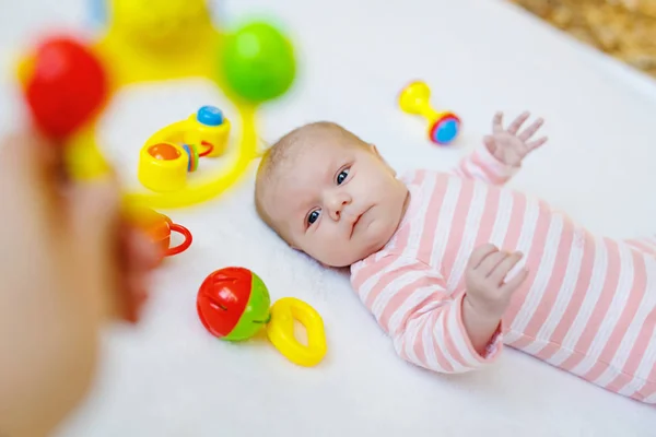 Linda niña jugando con juguetes de sonajero colorido —  Fotos de Stock