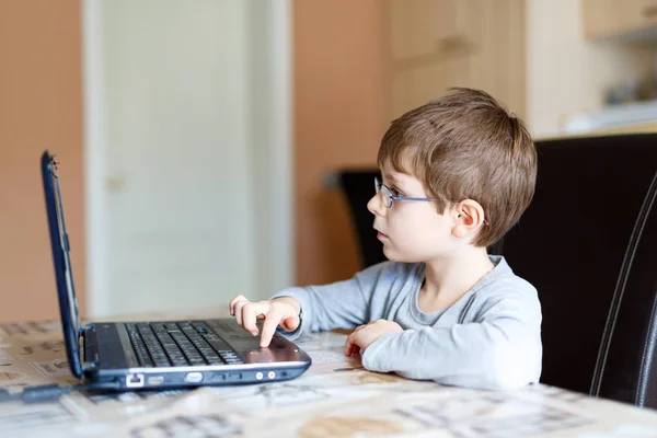 Kid boy med glasögon gör förskolan läxa på dator — Stockfoto