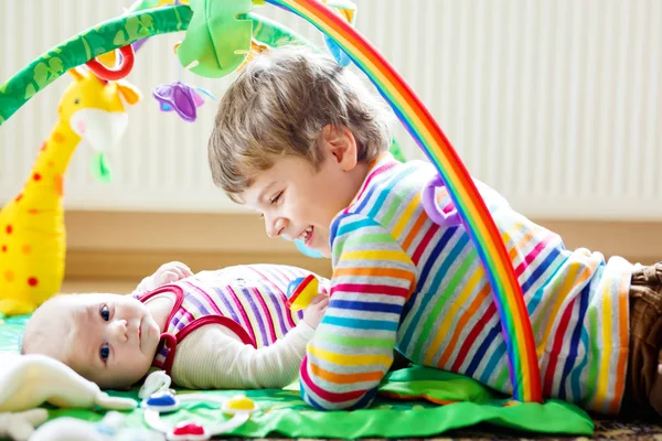 Gelukkig jongetje jongen met de zus van de pasgeboren baby meisje — Stockfoto