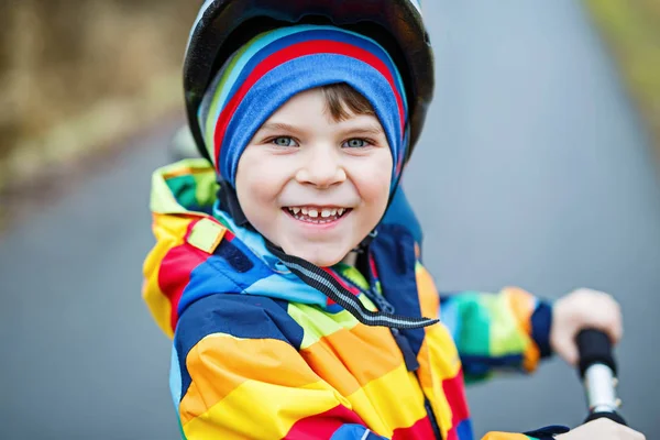 Bonito menino pré-escolar montando em scooter no parque — Fotografia de Stock