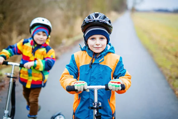 Two little kid boys, best friends riding on scooter in park — Stock Photo, Image