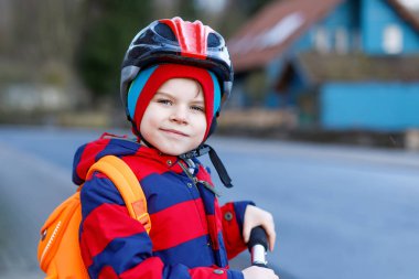 Sevimli küçük okul öncesi çocuk çocuk okula sürme scooter sürme.