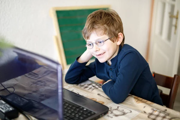 Kid boy med glasögon gör förskolan läxa på dator — Stockfoto