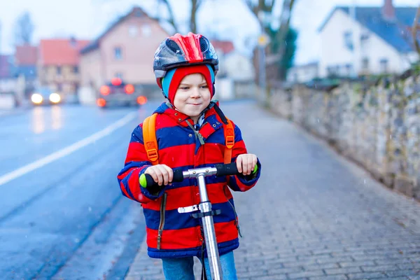 Bonito pouco pré-escolar menino equitação no scooter equitação para escola . — Fotografia de Stock