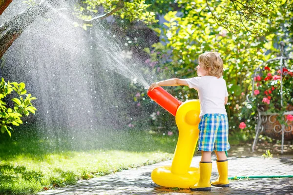 Little kid boy  playing  with a garden hose — Stock Photo, Image