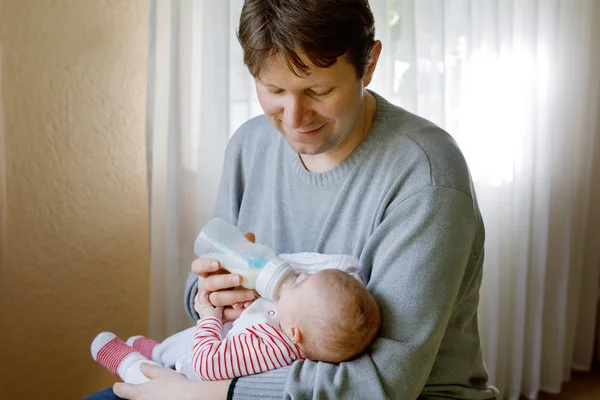 Vater füttert neugeborene Tochter mit Milch in Säuglingsflasche — Stockfoto