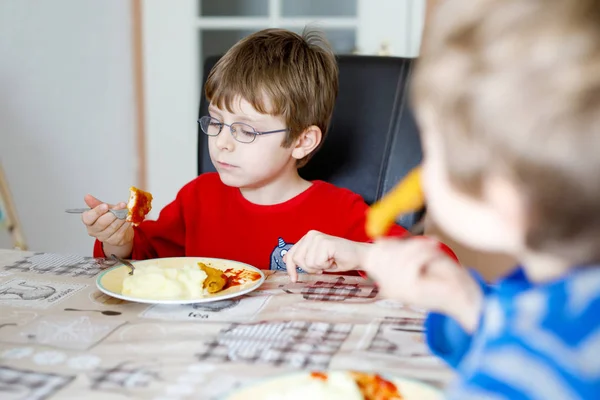 Dois meninos da escola comendo purê de batata e peito de frango em casa — Fotografia de Stock