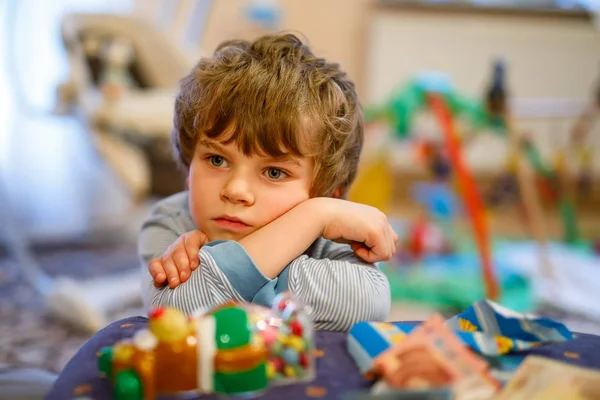 子供の誕生日に悲しい男の子の肖像画。おもちゃのたくさんの子 — ストック写真