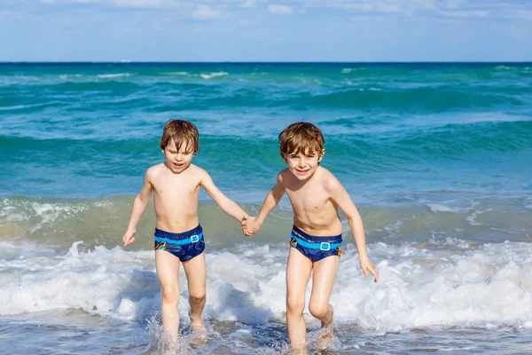 Dos niños corriendo en la playa del océano en Florida — Foto de Stock