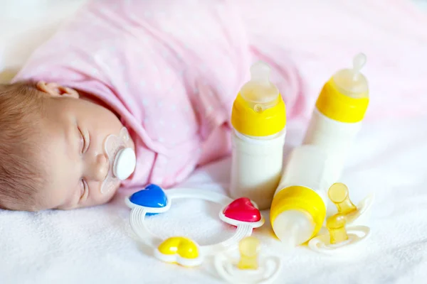 Roztomilé novorozeně dívka s ošet-řujícím lahví a dudlík — Stock fotografie