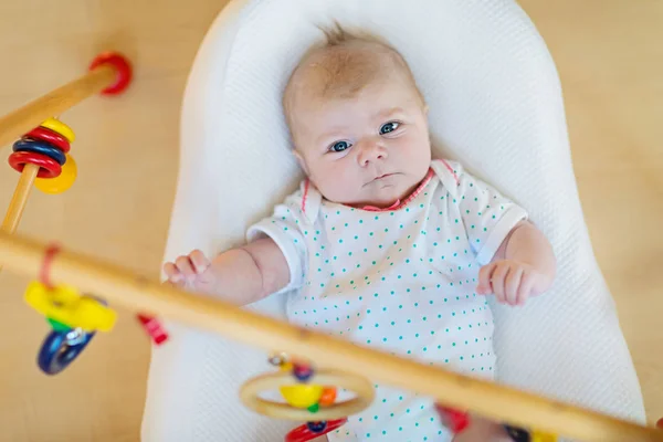 Cute baby girl playing with hanging wooden rattle toys — Stock Photo, Image