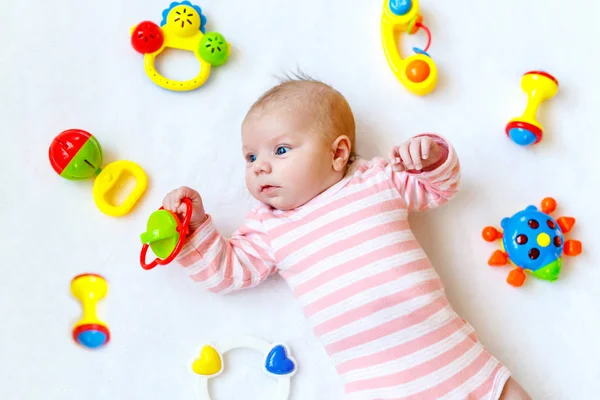 Bonito bebê menina brincando com brinquedos chocalho colorido — Fotografia de Stock