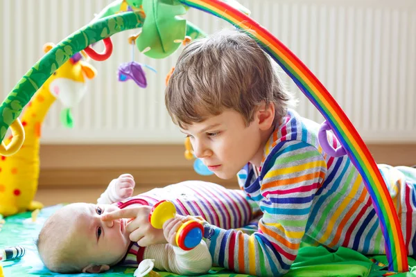 Gelukkig jongetje jongen met de zus van de pasgeboren baby meisje — Stockfoto