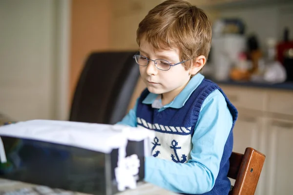 Дошкольный мальчик дома делает домашнее задание, рисует историю красочными ручками — стоковое фото