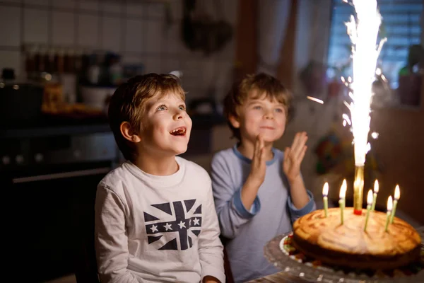 Two beautiful kids, little preschool boys celebrating birthday and blowing candles — Stock Photo, Image