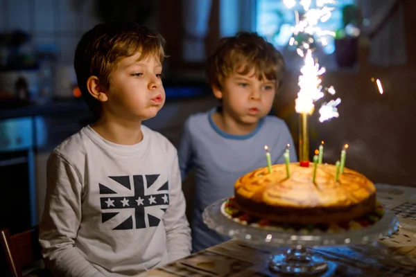Två vackra barn, lilla förskola pojkar firar födelsedag och blåsa ljus — Stockfoto