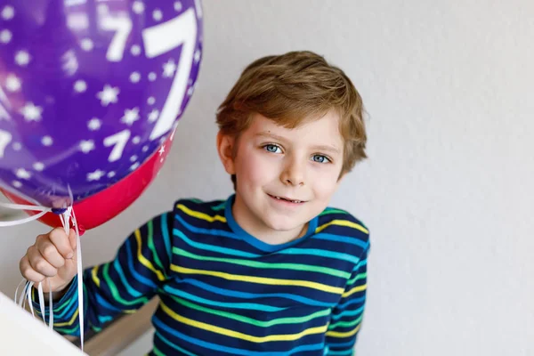 Porträtt av glad liten pojke med gäng på färgglada air ballonger på 7 födelsedag — Stockfoto