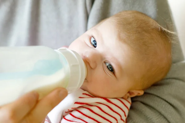 Отец кормит новорожденную дочь молоком в бутылке для кормления — стоковое фото
