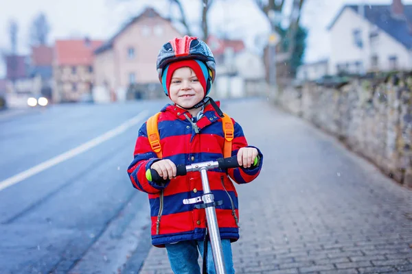 Mignon petit enfant préscolaire garçon équitation sur scooter équitation à l'école . — Photo