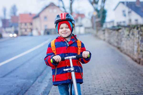 Söt liten förskola kid boy ridning på skoter till skolan. — Stockfoto