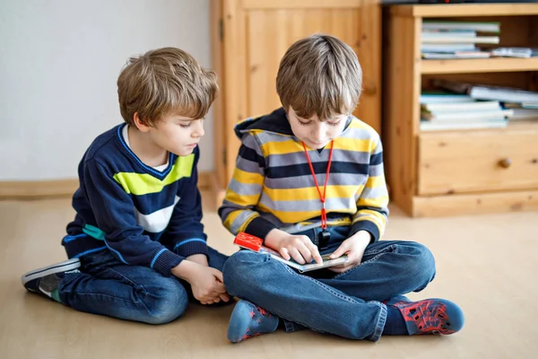 Two little kid boys reading a book at home — Stock Photo, Image