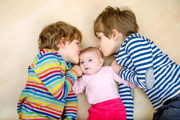 Two happy little preschool kids boys with newborn baby girl — Stock Photo, Image