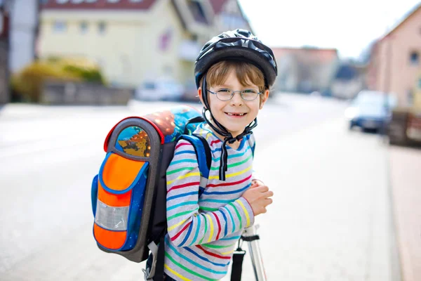 Маленький мальчик в шлеме едет на скутере по городу — стоковое фото