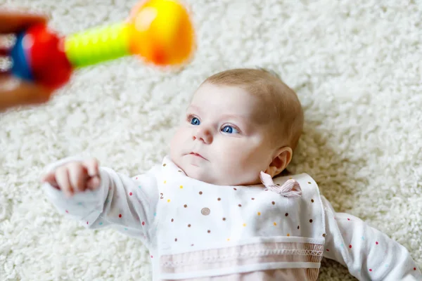 Bonito bebê menina brincando com colorido chocalho brinquedo — Fotografia de Stock