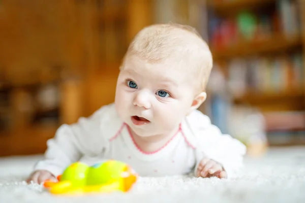 Adorable niña recién nacida acostada en el vientre en el dormitorio soleado blanco o guardería —  Fotos de Stock