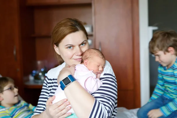 Mother holding newborn baby girl on arm with two kids boys — Stock Photo, Image