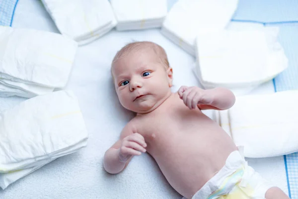 Newborn baby on changing table with diapers — Stock Photo, Image