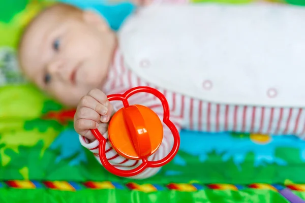 Cute baby girl playing with colorful rattle toy — Stock Photo, Image