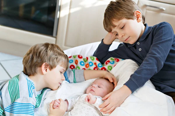 Duas crianças meninos brincando com bebê recém-nascido irmã menina — Fotografia de Stock