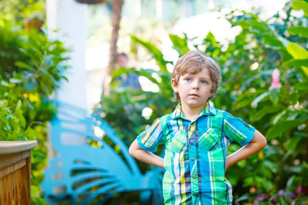 小さな金髪の幼児子供少年発見花や植物園のチョウ — ストック写真