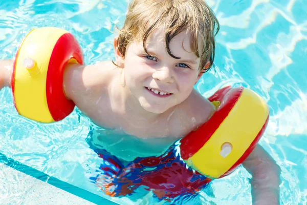 Happy little kid boy having fun in an swimming pool — Stock Photo, Image