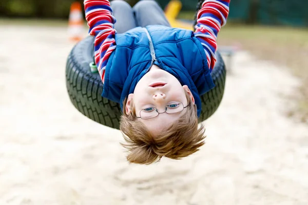 楽しいです子供男の子楽しいですチェーンスイングで屋外遊び場 — ストック写真