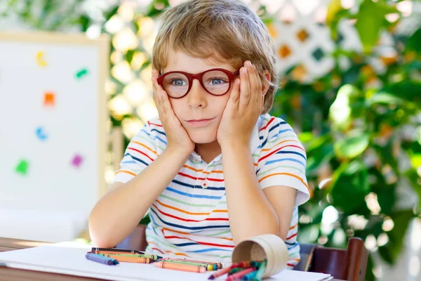 Menino com óculos segurando equipamento escolar — Fotografia de Stock