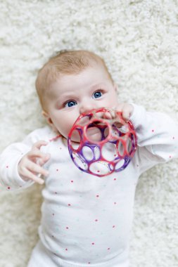 Renkli çıngıraklı oyuncakla oynayan tatlı bir kız.