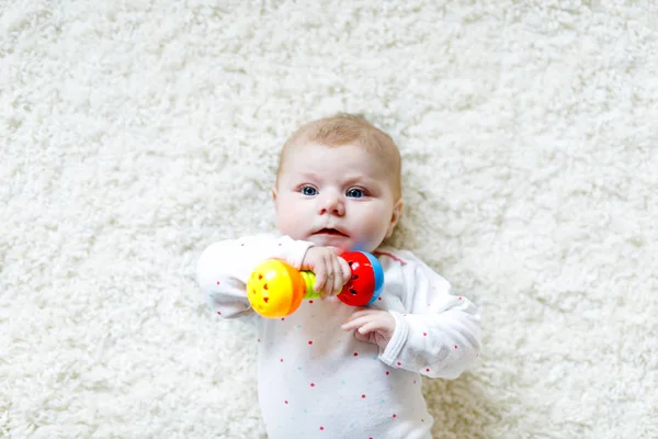 Bonito bebê menina brincando com colorido chocalho brinquedo — Fotografia de Stock