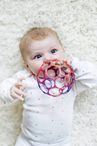 Cute baby girl playing with colorful rattle toy — Stock Photo, Image