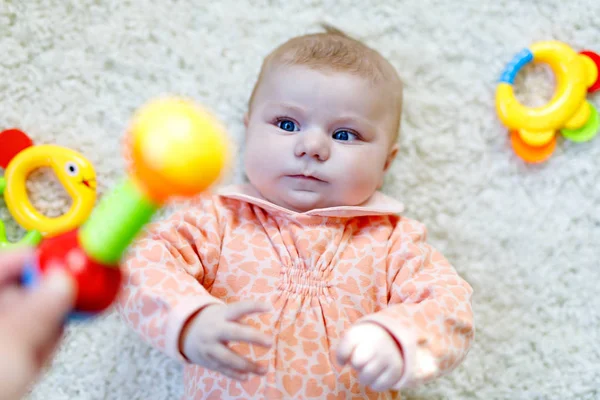 Linda niña jugando con colorido juguete sonajero — Foto de Stock