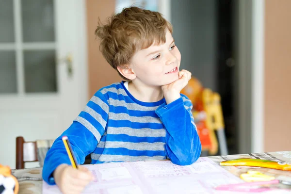 Menino da escola feliz em casa fazendo lição de casa — Fotografia de Stock