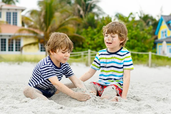 Due bambini piccoli ragazzi si divertono sulla spiaggia tropicale — Foto Stock