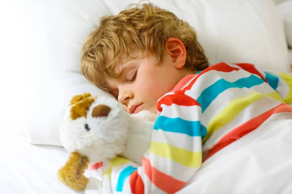 Pequeño niño rubio en ropa de dormir colorida — Foto de Stock