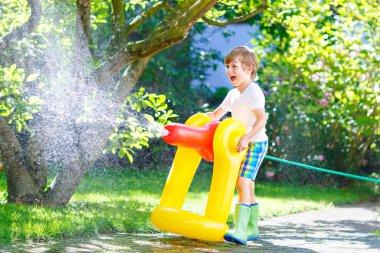 bir bahçe hortumu su yağmurlama ile oynarken küçük çocuk çocuk